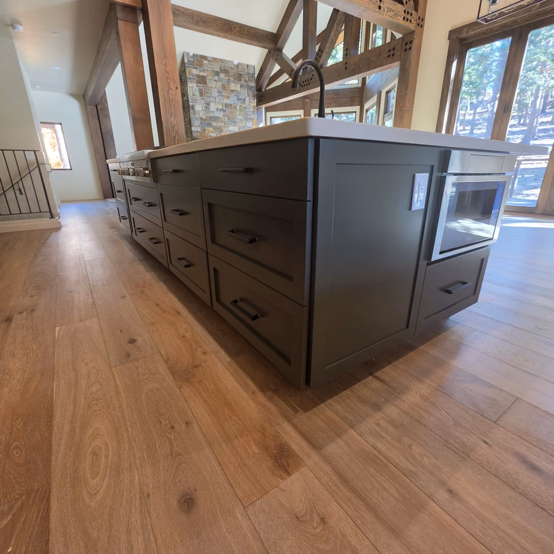 White quartz top on a dark green kitchen island