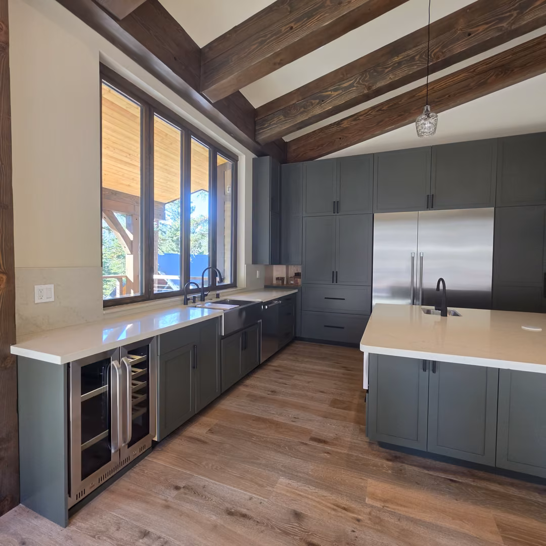 Green Shaker kitchen cabinets with a quartz top and a wine fridge