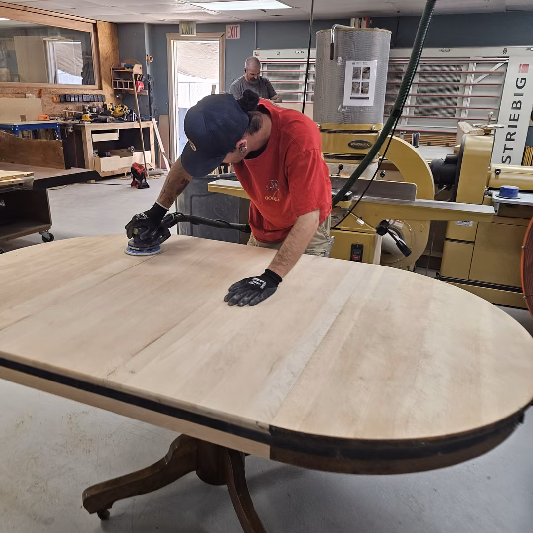 3R craftsman sanding a round tabletop